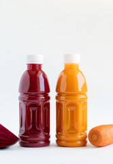 Bottles with carrot juice and beetroot juice on a white isolated background, copy space
