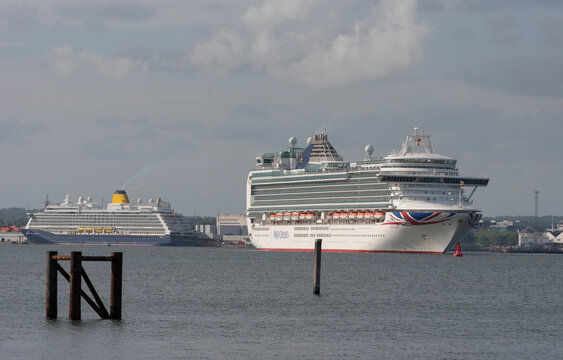 Southampton port, UK. 2022. Saga cruise ship Spirit of Adventure alongside and Iona underway heading out to sea.