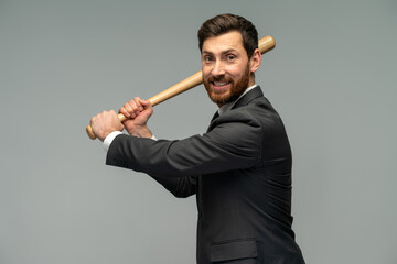 Waist up portrait view of the caucasian businessman swings with a baseball bat standing over grey background. Occupation concept