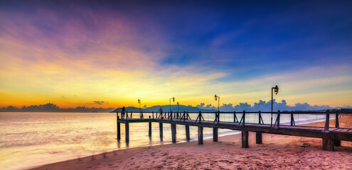 Fototapeta premium Sunrise on Wooden pier on city beach at Nha Trang, Vietnam in a summer day