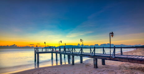 Obraz premium Sunrise on Wooden pier on city beach at Nha Trang, Vietnam in a summer day