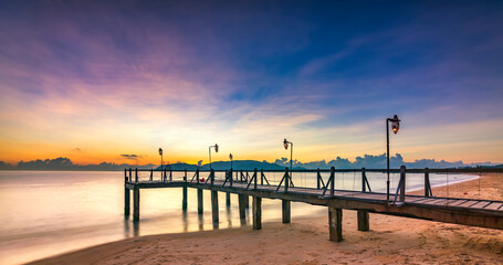 Fototapeta na wymiar Sunrise on Wooden pier on city beach at Nha Trang, Vietnam in a summer day