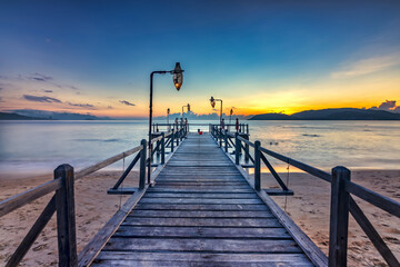 Sunrise on Wooden pier on city beach at Nha Trang, Vietnam in a summer day
