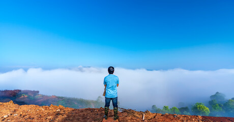 Silhouette of man standing on a high hill scenic rural hometown in the morning valley fog shrouded mountains looming large undulating scenic in Da Lat, Vietnam