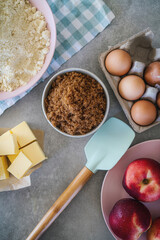 Peach or nectarine cake dessert ingredients. Butter, muscovado sugar, almond flour, eggs and nectarines. Horizontal flat lay top view focus directly from above. 