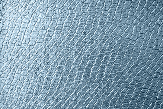 Silver crocodile or snake skin texture as background for your project with copy space for text. Artificial textile texture
