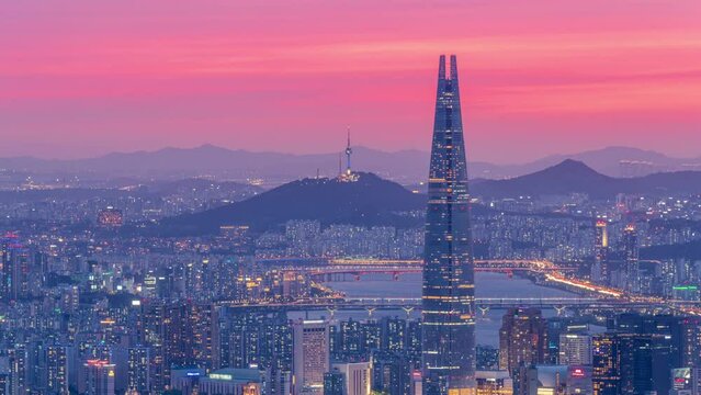 Zoom out,Time lapse 4k,The Sunset over the tops of Namsan and Lotte Tower in Seoul,South Korea.