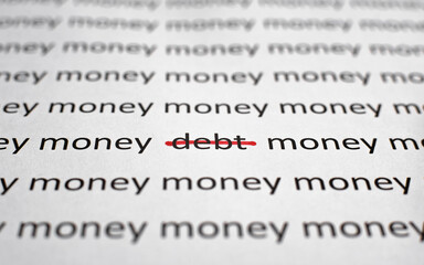 Obraz premium Printed text Money and Debt on white paper, close-up. Financial problems, economics and business concept. Selective focus on word debt crossed out with red line, low angle view, macro photo