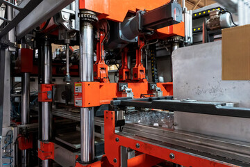 Vacuum thermoforming machine is used for producing plastic packaging in the factory. Close-up of the machine making a mold. Selective focus front