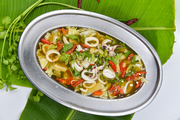 Steamed Squid in Lime Sauce - Thai food, top view on white background.