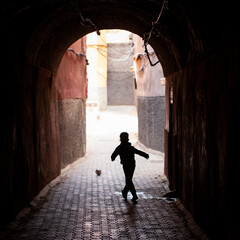 Niño jugando con pelota en callejón de Marrakech (Marruecos)