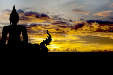 Silhouette with black buddha on sunset background.