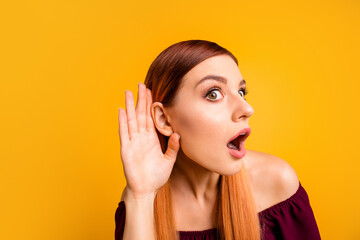Photo of funny excited young lady dressed red clothes arm ear listening you isolated yellow color...