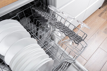 Open dishwasher with clean dishes in the kitchen