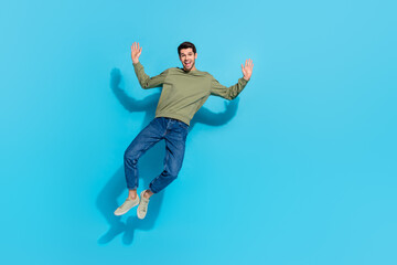 Fototapeta premium Full size photo of impressed young brunet guy jump wear shirt jeans sneakers isolated on blue background