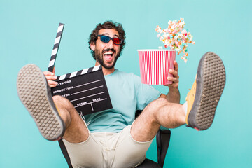 young adult hispanic crazy man. cinema clapper and pop corns. movie concept