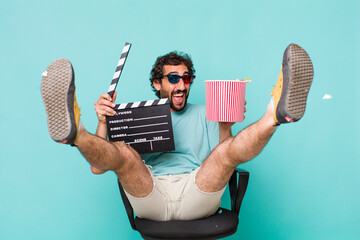 young adult hispanic crazy man. cinema clapper and pop corns. movie concept