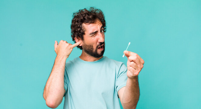 young adult hispanic crazy man using an ear swab