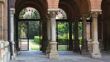 Fototapeta na wymiar Colonnade And Forged Gate At Inner Courtyard Of Ancient Castle 