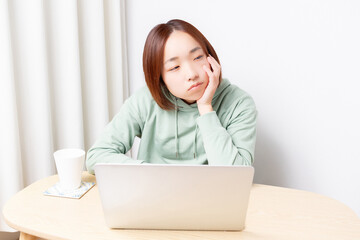 パソコンを使いながら落ち込んでいる女性