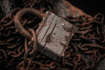 Old padlock on a rusty chain close-up. The concept of protection, safety, security.