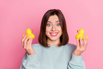 Photo of youth cheerful pretty lady good mood play small yellow duck isolated over pink color...