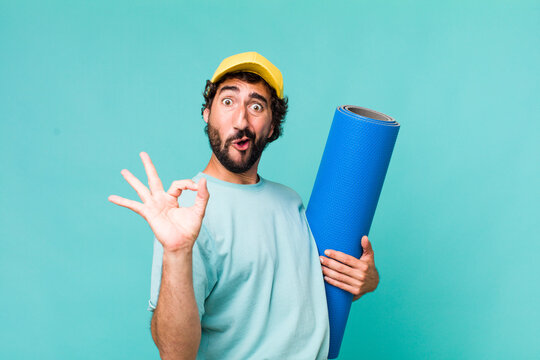 young adult hispanic crazy man with a yoga matt