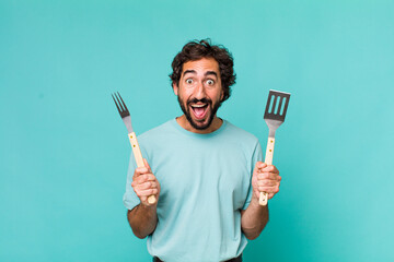 young adult hispanic crazy man with barbecue tools