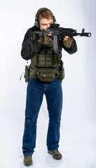 airsoft player in full gear with weapons series GG RK74 fire. a man in an outfit, in headphones, a bulletproof vest, with a backpack and a belt. White background.