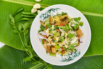 Spicy Crispy Gouramy Fish Salad - Thai food, top view on white background.