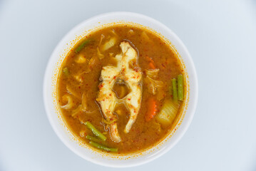 Mixed Vegetable Sour Soup with Red Tilapia Fish - Thai food, top view on white background.