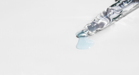 Pipette with fluid hyaluronic acid on blue background. Cosmetics and healthcare concept closeup. Dose of serum, retinol with air bubbles. Flat lay. Luxury beauty product presentation, macro. Banner