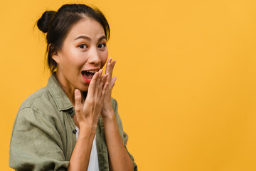 Young Asia lady feel happiness with positive expression, joyful surprise funky, dressed in casual cloth and looking at camera isolated on yellow background. Happy adorable glad woman rejoices success.