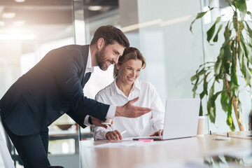 Female boss discussing online project with employee showing presentation to experienced team leader