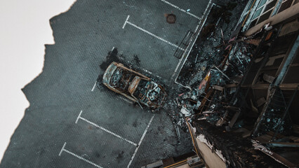 Russian invasion of Ukraine war torn city destroyed car burn out. Russia war damage building destruction city war ruins city damage car. Disaster area. cars beaten by shrapnel and burnt. Drone photo