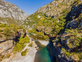 Sights of Montenegro. Landmark Old rusty bridge. Attraction Long extreme suspension iron bridge across the river Moraca. Montenegro
