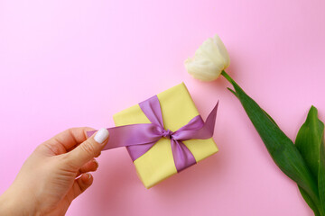  Womans hand holding Gift box on color background. Happy womens day. Happy Mothers day.Hello Spring- Image