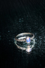ring with Moonstone   on black background  with water drops- Image