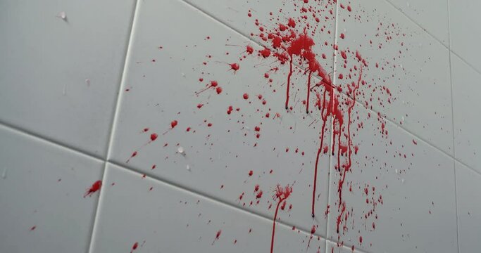 Blood splash on  on white tiled wall
