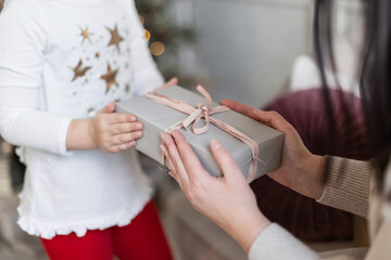 woman's hands hold a Christmas present. A mother gives a gift to a child. Merry Christmas and Happy new Year