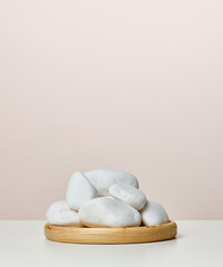 A pile of round white stones on a wooden stand, a stage for displaying products