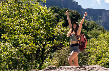 mountaineer woman raising her arms happy