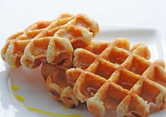 Two waffles with syrup on a plate