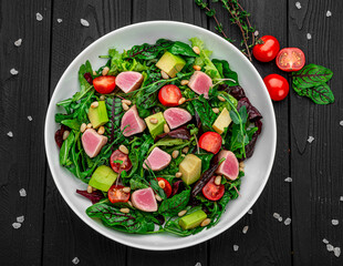 Japanese traditional salad with pieces of medium-rare grilled Ahi tuna and sesame with fresh vegetable on a bowl.