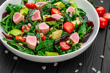 Japanese traditional salad with pieces of medium-rare grilled Ahi tuna and sesame with fresh vegetable on a bowl.