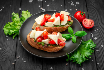 Bruschetta with cherry tomatoes, mozzarella cheese and pesto sauce.