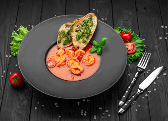 Seafood tomato soup bouillabaisse with croutons and pesto sauce