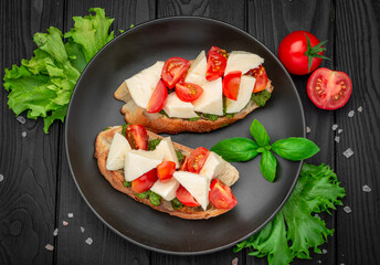 Bruschetta with cherry tomatoes, mozzarella cheese and pesto sauce.