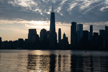 Fototapeta na wymiar NYC Manhattan skyline in silhouette during sunrise , travel theme, vivid textured city life photograph. Wide angle perspective horizontal.