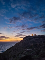 Beautiful sunset over the cliff of The Temple of Poseidon at Cape Sounion, over the Aegean Sea Greece